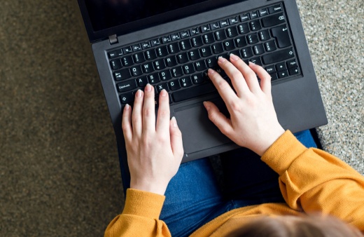 Photo of a student typing on a laptop