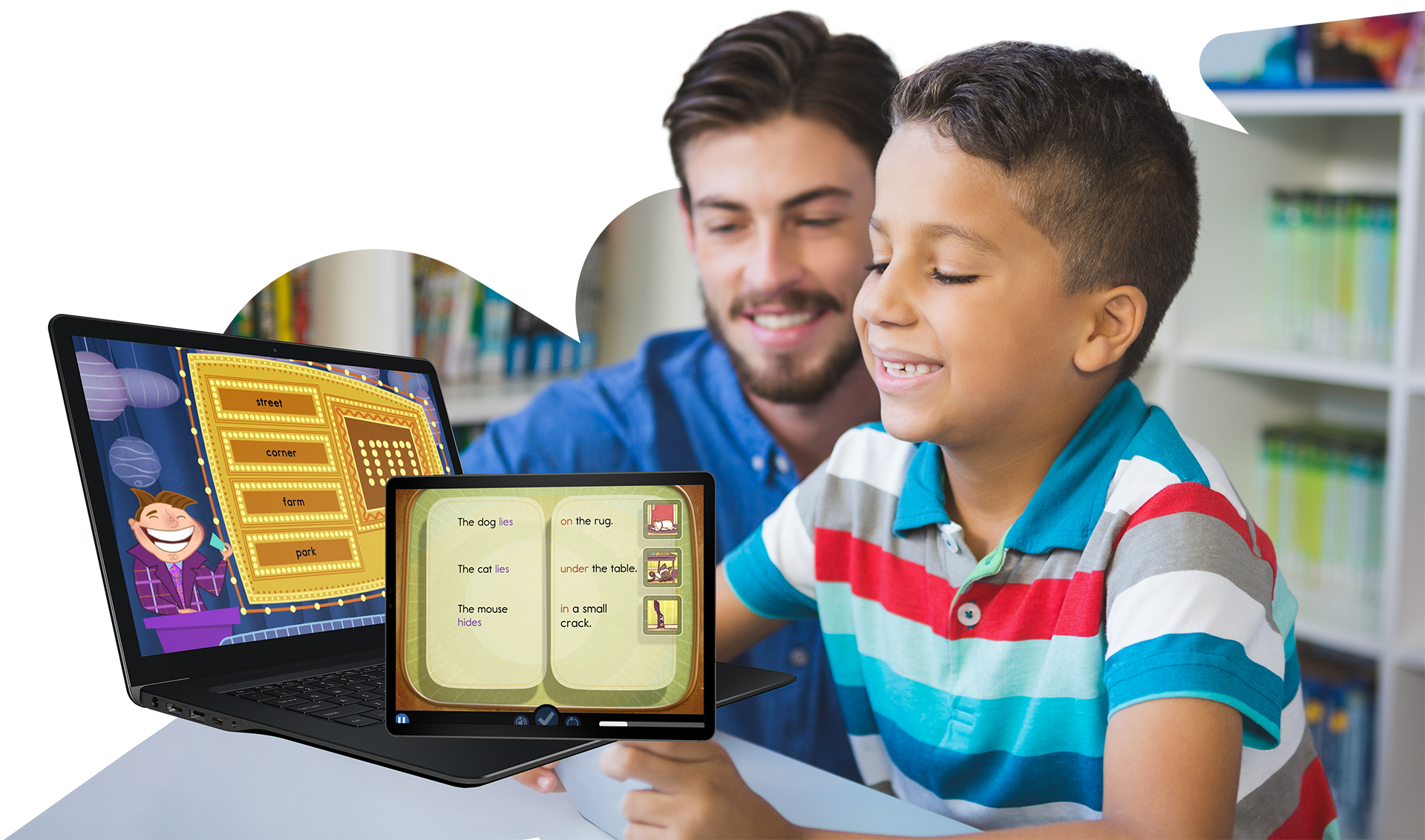 An elementary student is sitting at a desk and smiling while looking at a tablet. A smiling teacher is pointing at the screen over the student's shoulder.